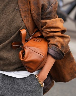 Paris, France - October, 6, 2025: Woman wears brown Miu Miu leather shoulder bag. Fashion outfit handbag detail, street style look accessory